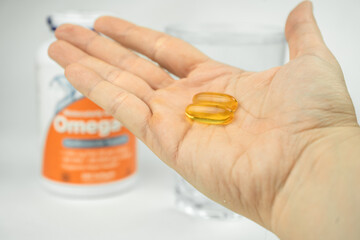 omega 3 fish oil big gel capsules and glass of water, healthcare, vitamins