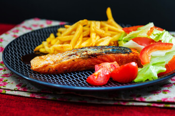 grilled salmon and lemon - french cuisine dish with tomato and salmon