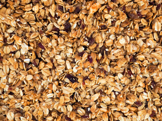Organic homemade roasted granola with with cranberries on baking sheet. Food for breakfast. Meal background, granola texture.