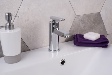New and modern steel faucet with the ceramic sink in the bathroom