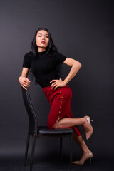 Young beautiful Asian transgender businesswoman against black background