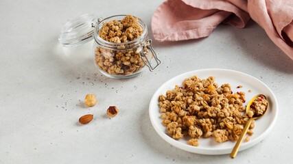 Banner homemade granola with nuts in a plate with a spoon. healthy breakfast concept, vegetarian breakfast. Copy space.