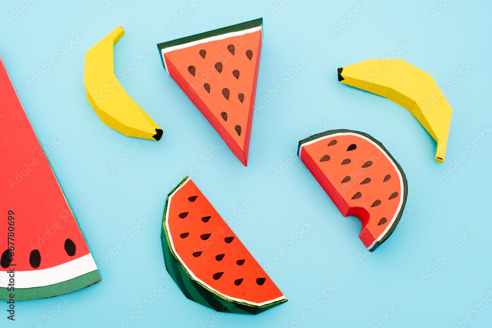 Wall mural top view of paper watermelon and bananas on blue background