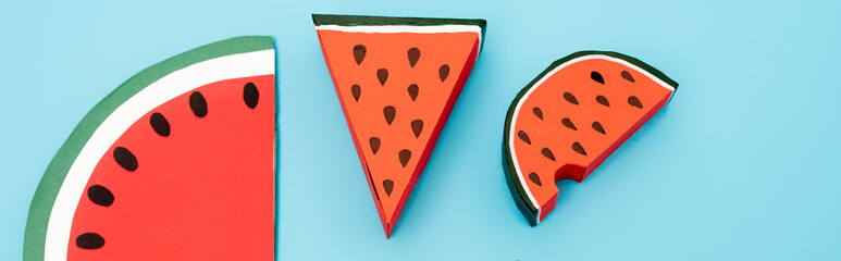 top view of paper watermelon slices on blue background, panoramic shot