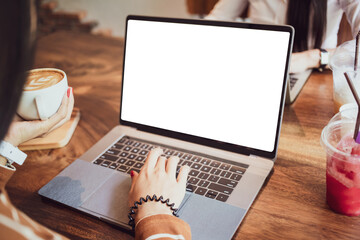 young woman holding cup of latte hot coffee and using laptop white mock up shopping online