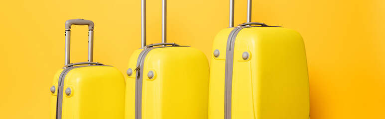 stack of travel bags on yellow background, panoramic shot