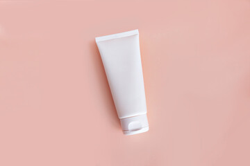 Blank cosmetic tube on a beige background