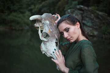 Young girl holding animal skull. Scary, horror concept