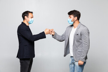 Fist bump greeting. Two people in suits greet each other in a meeting. They give up the untraditional handshake isolated on a white background. Covid concept