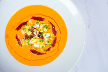 Traditional spanish Salmorejo. Cold tomato soup made with garlic, tomatoes, onion, bread and served with olive oil, iberico ham and boiled egg.