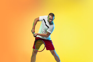 Fototapeta na wymiar One caucasian man playing tennis isolated on studio background in neon light. Fit young professional male player in motion or action during sport game. Concept of movement, sport, healthy lifestyle.