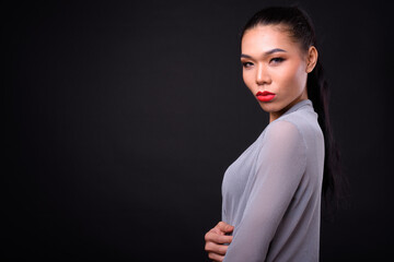 Fototapeta premium Young beautiful Asian transgender woman against black background