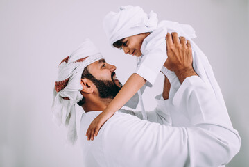 Handsome man with traditional white kandura from uae. Studio portraits with father and son