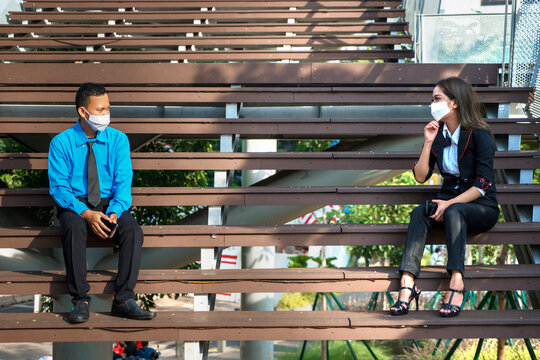 Business couple apply physical distance on stairs