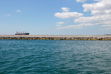 Iron freighter. Flying seagulls. Ship like going over the breakwaters
