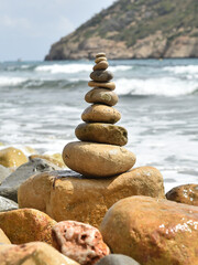 Fototapeta na wymiar una torre de piedras redondas en una playa del mediterraneo