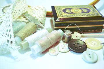 Sewing accessories in beige and ecru colours including vintage wooden box, sewing spools, buttons, scissors,  cotton lace, crotchet. Scrapbooking and DIY. Hobby and needle work. Retro style.  Closeup 