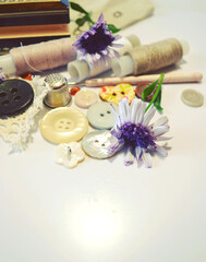 Sewing accessories in beige and ecru colours including cotton lace, sewing spools, buttons and flowers. Scrapbooking and DIY. Hobby and needle work background. Retro style composition