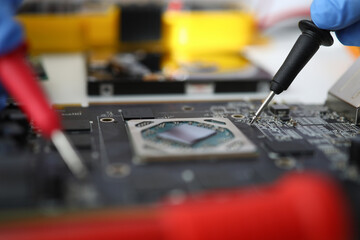 Master makes diagnostics of motherboard with tester. Electronic circuit board service concept