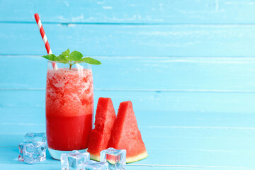 Refreshing colorful watermelon juice with mint on blue old wooden the table background with copy space.