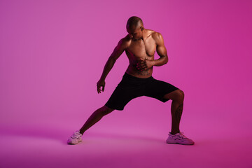 Fototapeta na wymiar African fitness sports man isolated over pink wall
