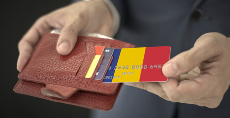 Man pulls plastic bank card with flag of Romania out of his wallet, fictional card number