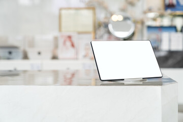 Mockup tablet with blank white screen on table.