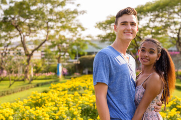Fototapeta premium Portrait of young multi ethnic couple relaxing together at the park