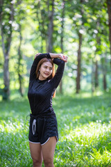 Asian women are Warm up the body before exercise. In a garden with many green trees