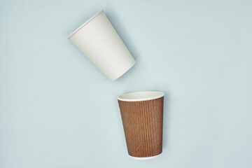 Paper cup in hand on a colored background. Eco-friendly materials in a coffee shop, biodegradable disposable tableware. Close up.