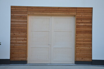 New double door framed in wood on a white wall