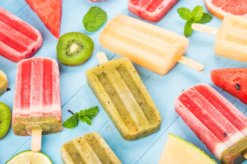 Healthy Whole Fruit Popsicles with Berries Kiwi watermelon cantaloupe on wooden vintage table