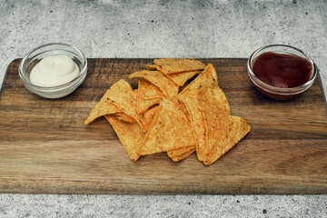 Corn cheese, snacks with sauce on a wooden stand. Beer snack, dish on the menu. Close up.