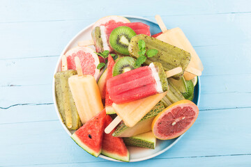 Healthy Whole Fruit Popsicles with Berries Kiwi watermelon cantaloupe on wooden vintage table