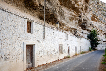 Fototapeta na wymiar Narrow white brick houses next to the cliff wall of the Jucar river in Spain.