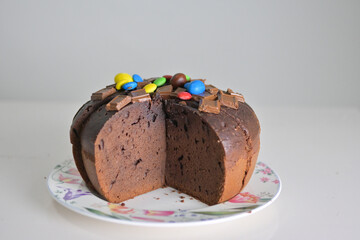 brownie chocolate cake in the dish on the white table on top with chocolate 