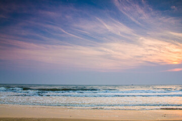 Sun is fall down sunset with sea and beach and waving clear sky