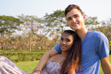 Portrait of young multi ethnic couple relaxing together at the park