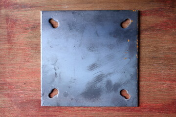 Iron plate, Steel Plate with screws on a wooden background