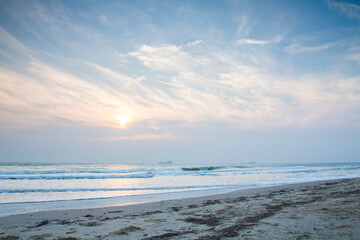Sun is fall down sunset with sea and beach and waving clear sky