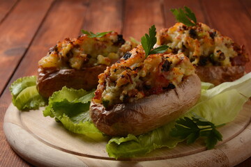 Fried potatoes with mushrooms in a wooden bowl. Rustic style.