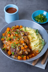 Ossobuco. Veal (beef) shanks with mashed potatoes, gremolata and sauce. Traditional Italian dish. Close-up.