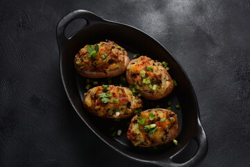 Fried potatoes with mushrooms in a plate/and frying bowl with herbs.
