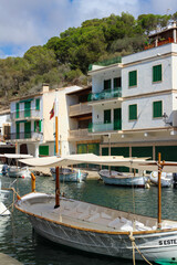 white houses with green shutters and doors in the fishing village of Cala Figuera and boats...