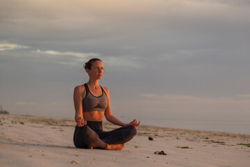 Woman meditating on the beach