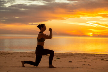 Fototapeta na wymiar Woman doing split squats on the beach