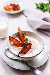 Milk Buckwheat Porridge with Caramelized Pears on grey concrete background. Healthy breakfast. Selective focus