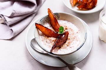 Milk Buckwheat Porridge with Caramelized Pears on grey concrete background. Healthy breakfast. Selective focus