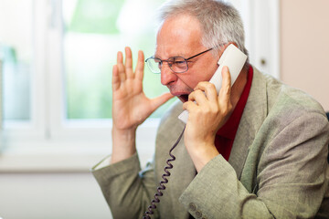 Portrait of an angry businessman yelling at phone