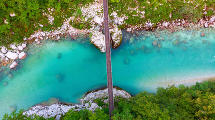Aerial view of the turquoise blue Soca river (Isonzo) and wooden bridge near Bovec in the Julian...